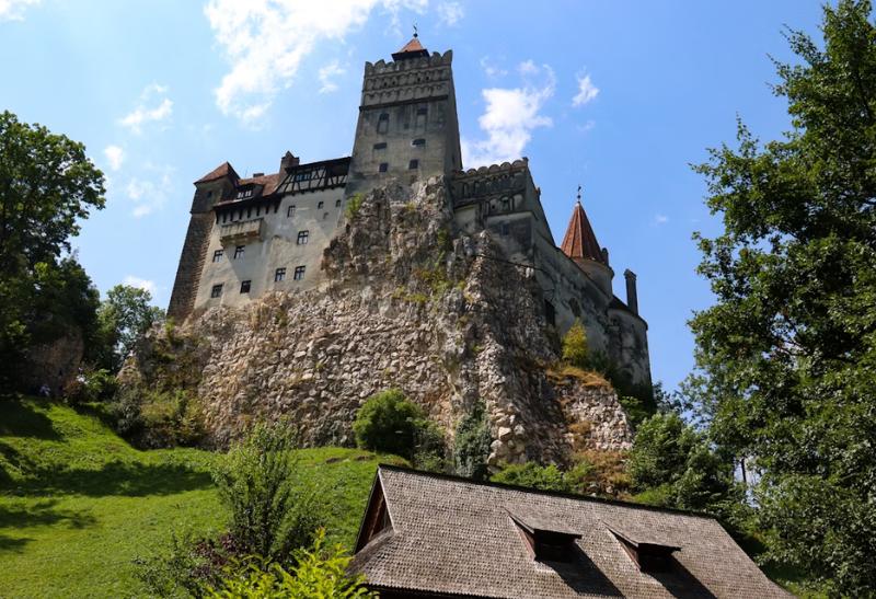 Hrad Bran na brale a drevený dom.