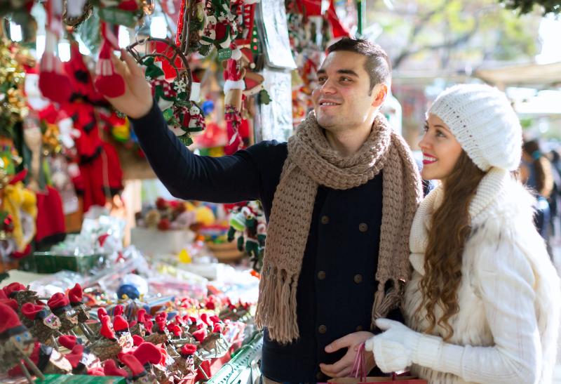 Mladý pár na vianočných trhoch pri stánku.
