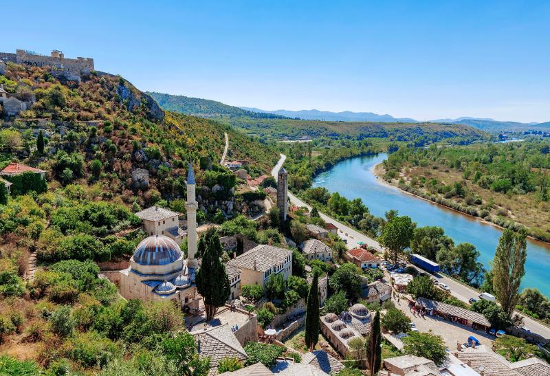 Zelený svah, mešita a rieka.