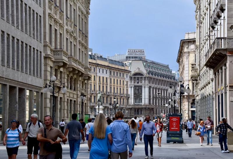 Rušná ulica v Miláne počas dňa a chodci.