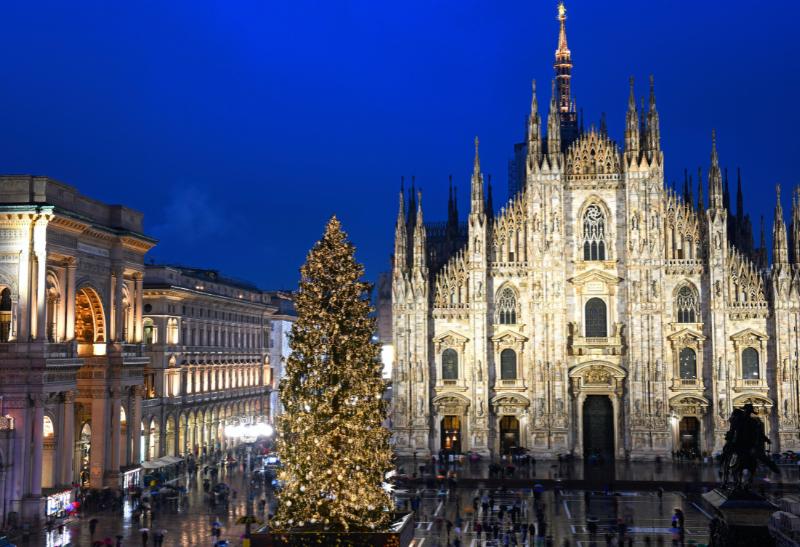 Adventné Miláno večer, vysvietená katedrála Duomo a vianočný stromček.