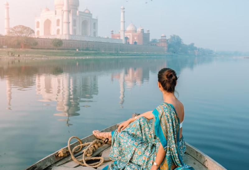 Žena na lodi pri Tádž Mahál v Indii.