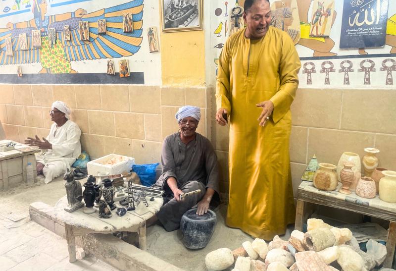 Veselí Egypťania v remeselnej dielni pri výrobe výrobkov z alabastru v Egypte.