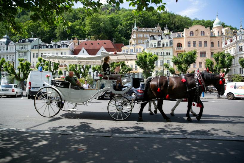 Koč a historické budovy v meste Karlove Vary.