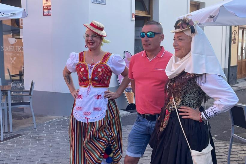 Dve ženy v kroji a turista.