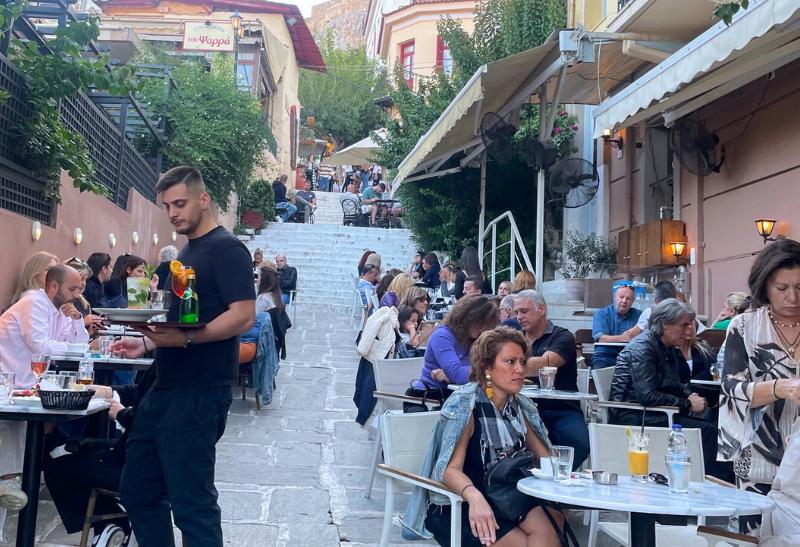 Podvečerná Plaka v Aténach a reštaurácia na schodoch s ľudmi.