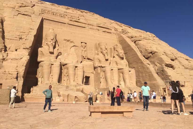 Chrám v Abu Simbel s veľkými sochami faraóna a návštevníci.