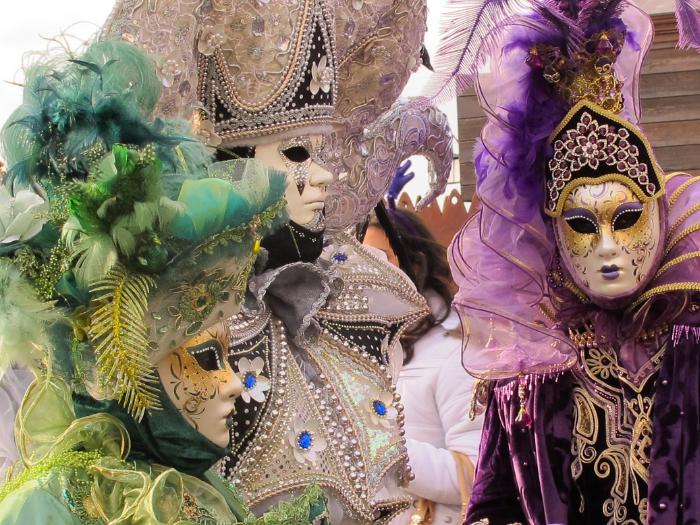 Tri zdobené masky na karnevale.