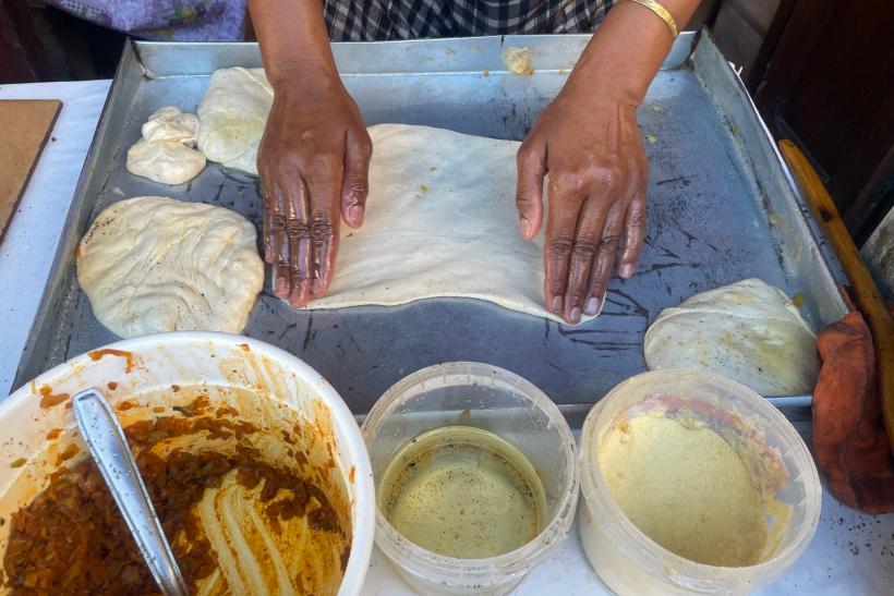 Miestna žena pripravuje cesto na palacinky msamen.