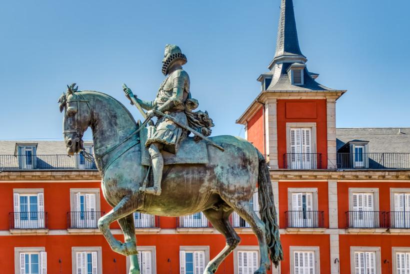 Socha, červená budova na námestí Plaza Mayor v Madride. Španielsko