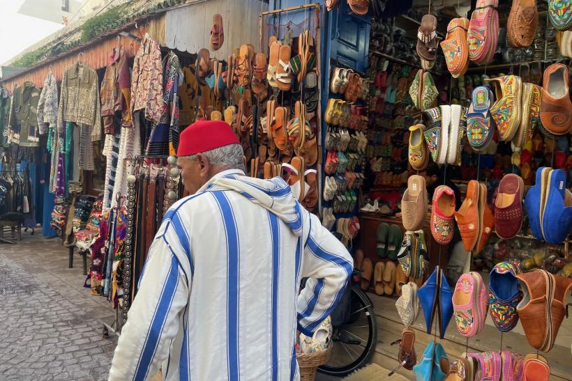 Maročna v červenej čiapke idúci cez trh v Essaouire v Maroku.