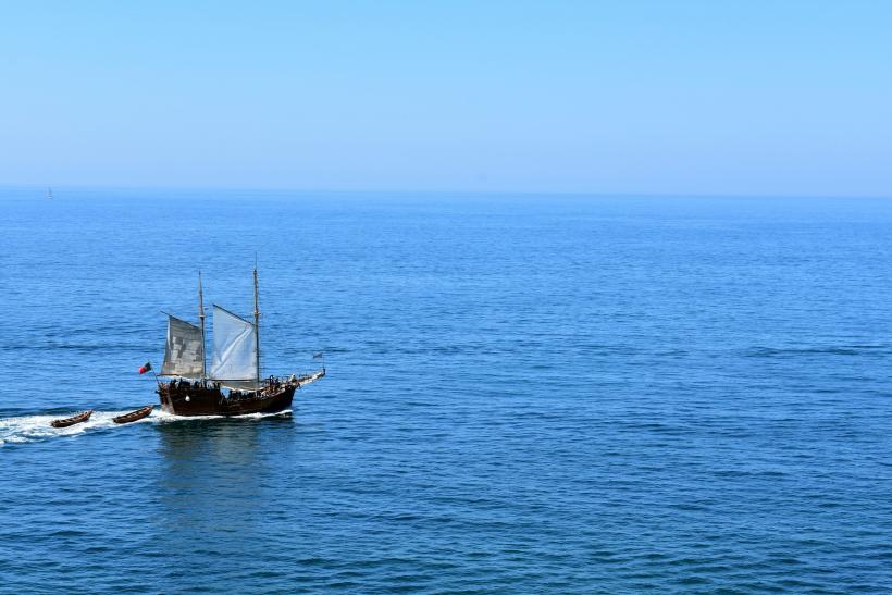 Drevená loď na mori s portugalskou vlajkou.