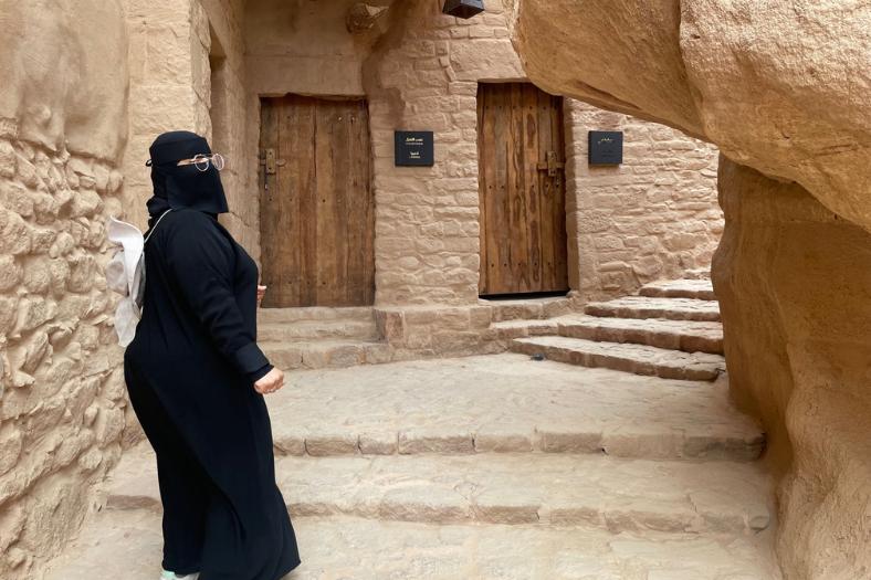 Saudská sprievodkyňa odetá do čiernej abáji. AlUla. KSA