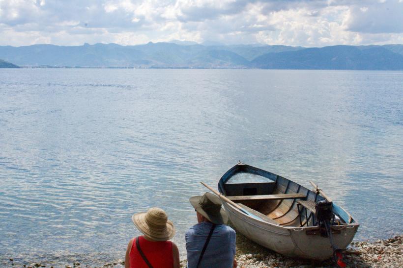 Dvaja ľudia relaxujú pri jazere Ohrid.