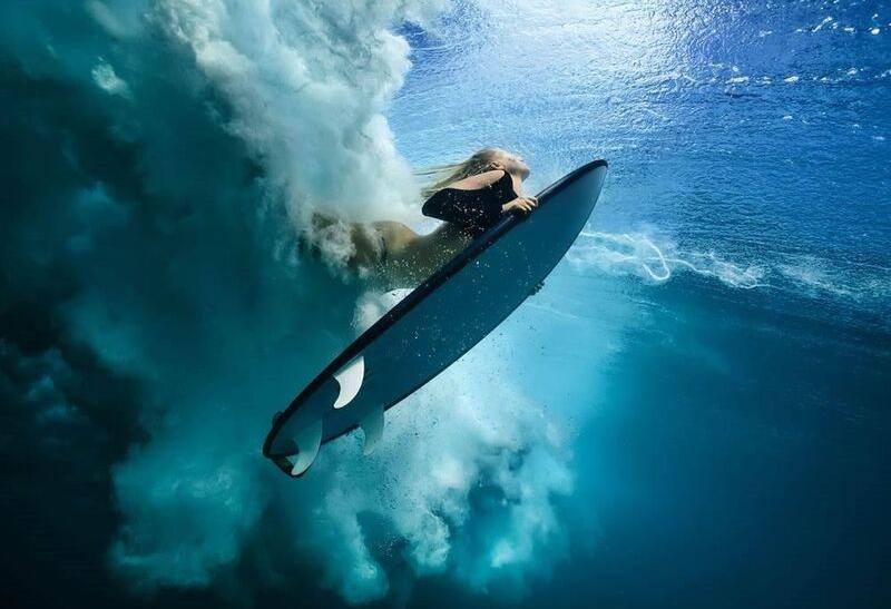 Žena surfujúca vo vlnách.