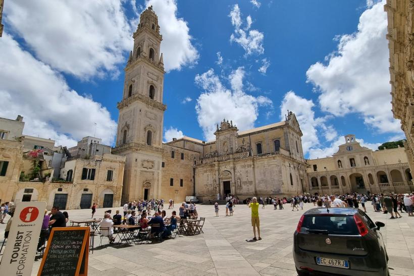 Námestie Duomo s kostolom, historickými domami a ľudia v meste Lecce.
