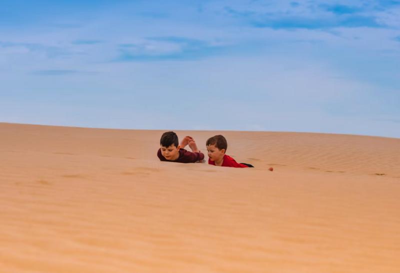 Dve deti na pieskovej dune.
