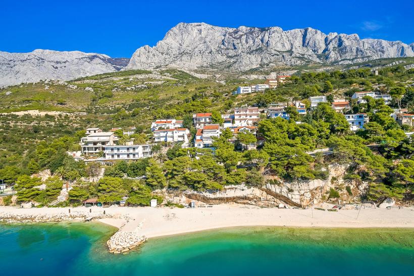 Pohľad na apartmány na horskom masíve na Makarskej a krásne tyrkysové pobrežie.
