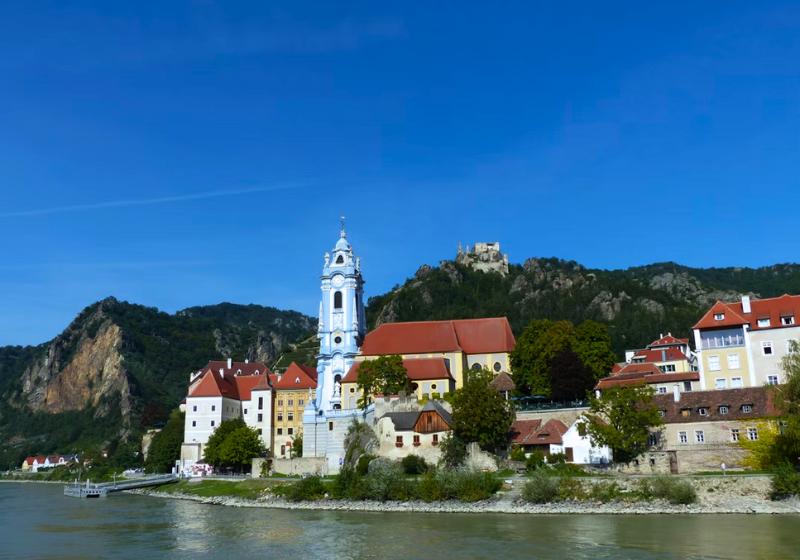 Kostol a historické domy pri rieke Dunaj v Údolí Wachau, Rakúsko.