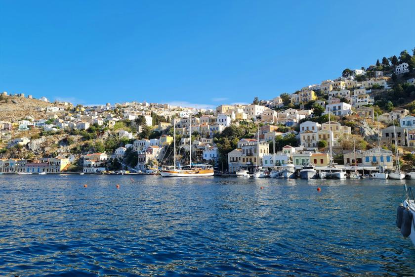 Modré more, lode a farebné domy na ostrove Symi.