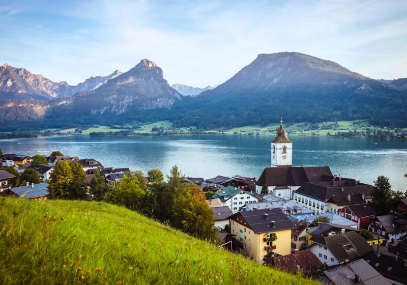 Mesto St. Wolfgang s domami, kostolom pri jazere a okolité hory, Rakúsko