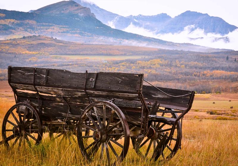 Starý drevený voz a hory v provincii Alberta. Kanada. Foto: unsplash.com