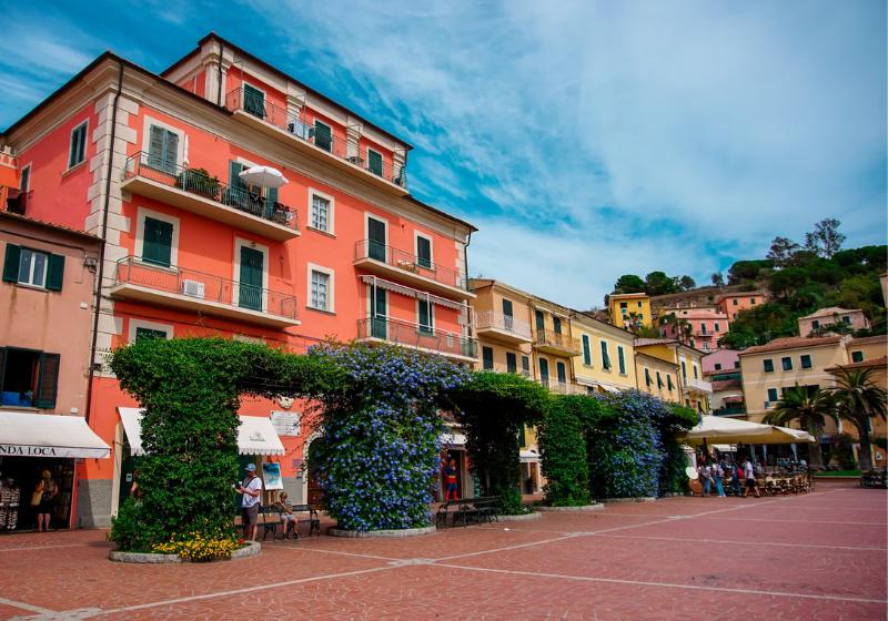Farebné námestie - budovy a zelené kvety v Porto Azzuro, Taliansko. Foto: unsplash.com