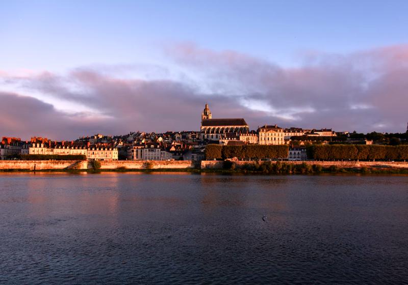 Mesto Blois, katedrála a zámok pri západe slnka s odrazom na vode. Francúzsko. Foto: unsplash.com