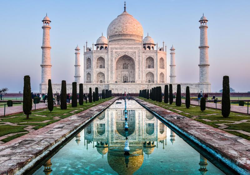 Biela mramorová stavba s kupolami, vežami, záhradou a bazénom. Tádž Mahal, India