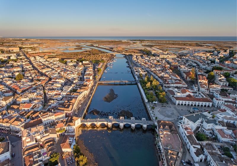 Historická Tavira na brehoch rieky a oceán v pozadí. Portugalsko.