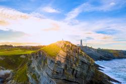 Región Cantabria - zelené pobrežie, oceán a maják. Španielsko. Foto: unsplash.com