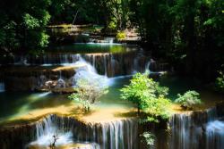 Vodopády a kaskády pretekajúce zeleným lesom v národnom parku Erawan. Thajsko