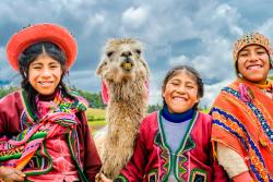Deti pestro oblečené do ponča a lama. Pisac. Peru. Foto: unsplash.com