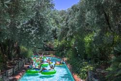 Deti splavujú rieku na veľkých kolesách.