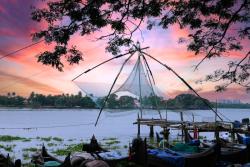 Lode pri vode, pri západe slnka v meste Kochi v Indii.