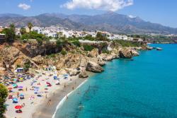 Biele mesto Nerja pri pobreží a piesková pláž