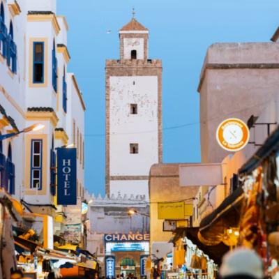 Rušná ulica v Essaouire s domami a mešitou.