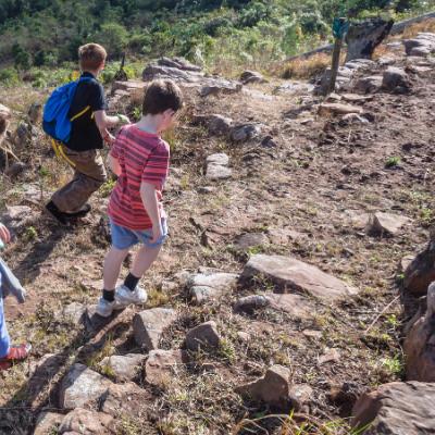 Deti kráčajúce chodníkom v horách.