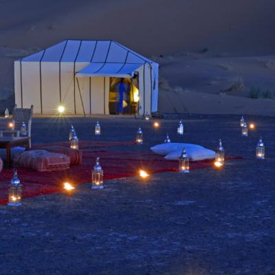 Ubytovanie v púšti a vysvietený kemp s lampami.