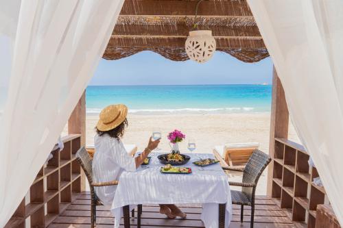 Pláž, reštaurácia a žena pri stole v hoteli caesar bay