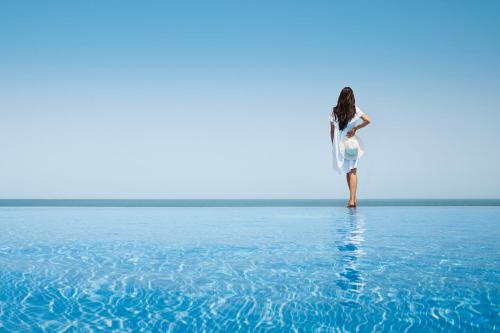 Žena pri bazéne v Anantara Sir Bani Yas Island Desert Islands Resort & Spa