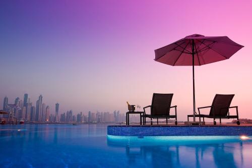 Ležadlá pri bazéne v Dukes Dubai, a Royal Hideaway Hotel