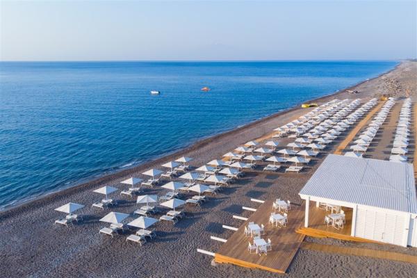Pláž so slnečníkmi a ležadlami pred hotelom Gennadi Grand Resort