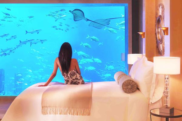 Žena v izbe s aquáriom v hoteli Atlantis, The Palm