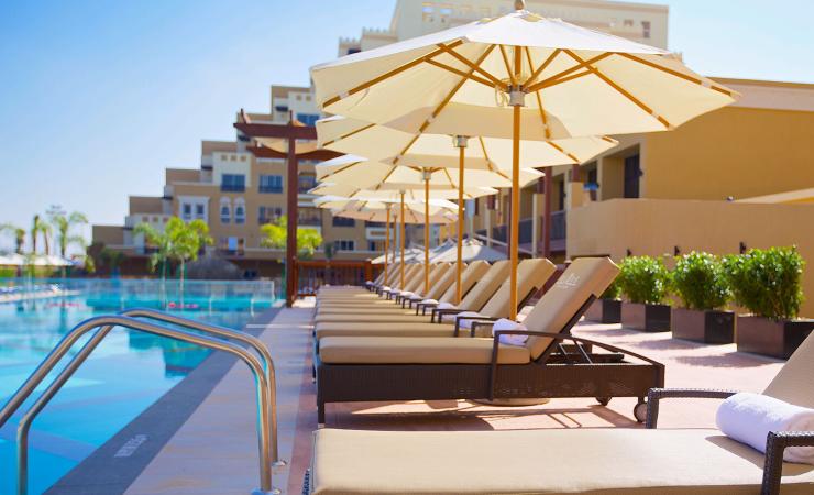 Ležadlá pri bazéne v hoteli Rixos Bab Al Bahr