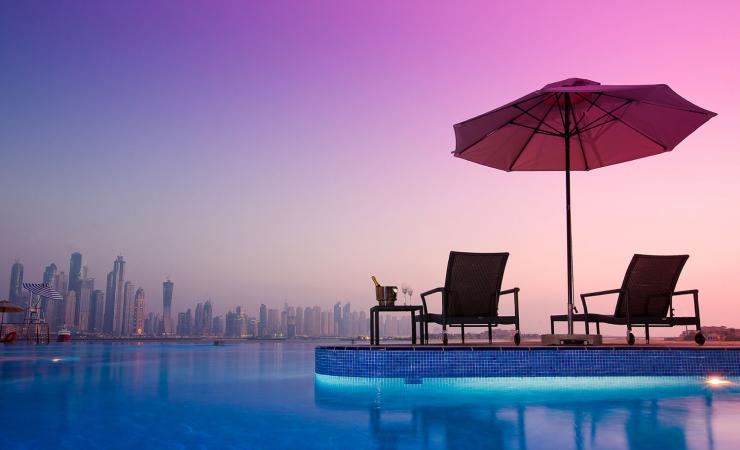 Ležadlá pri bazéne v Dukes Dubai, a Royal Hideaway Hotel