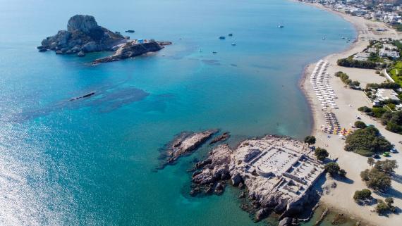 Letecký pohľad na pláž Agios Stefanos s ruinami baziliky a ostrovom Kastri pri ostrove Kos, Grécko