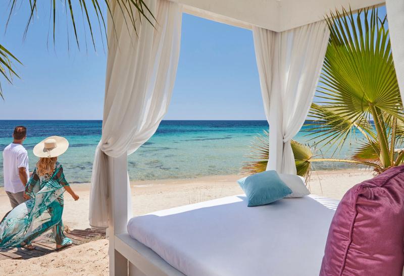 Pár idúci po pieskovej pláži pri mori