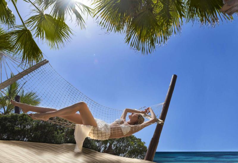 Žena v hojdacej sieti na pláži.