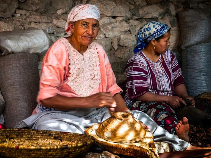 Sediace ženy v  továri pri spracovaní arganových orieškov.
